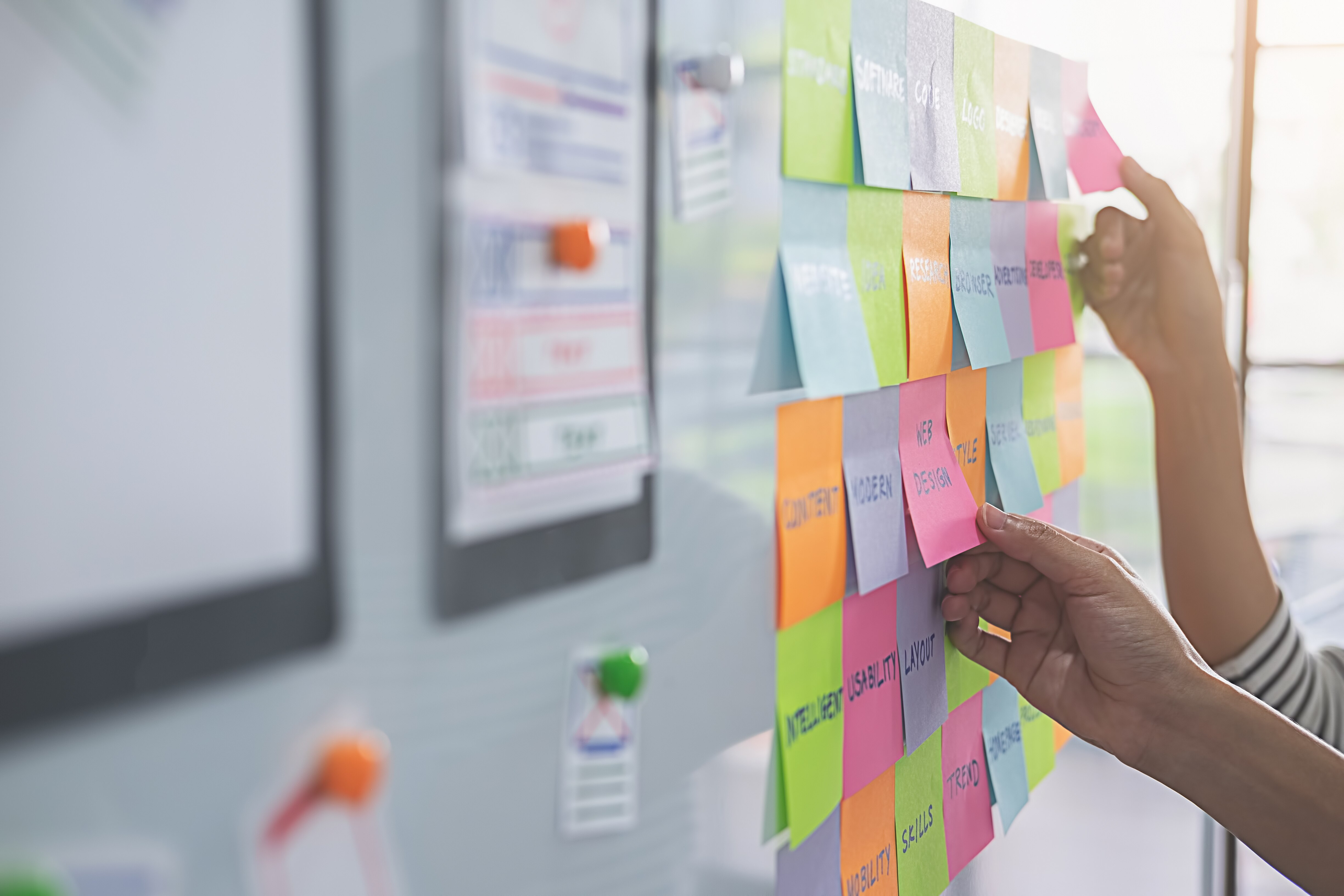 Web designer brainstorming for a strategy plan. Colorful sticky notes with things to do on office board. User experience (UX) concept. Web designer brainstorming for a strategy plan. Colorful sticky notes with things to do on office board. User experience (UX) concept.