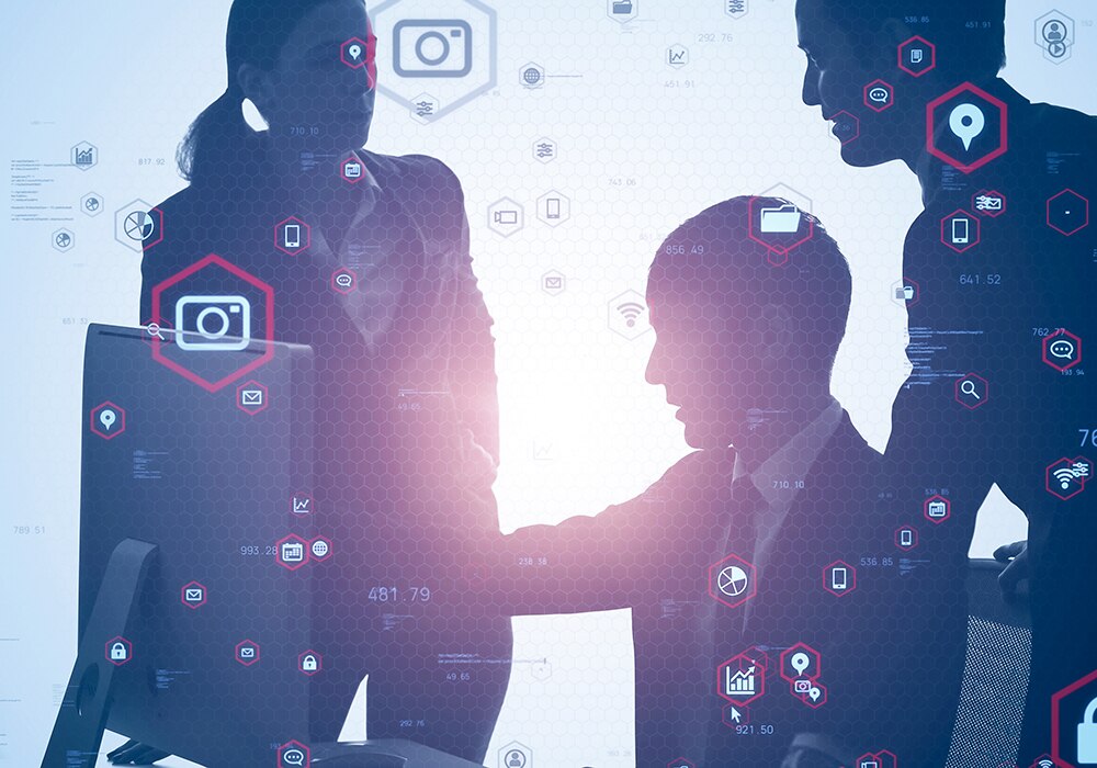 ビジネスの場で握手を交わす3人のビジネスマンのシルエットのイメージ画像