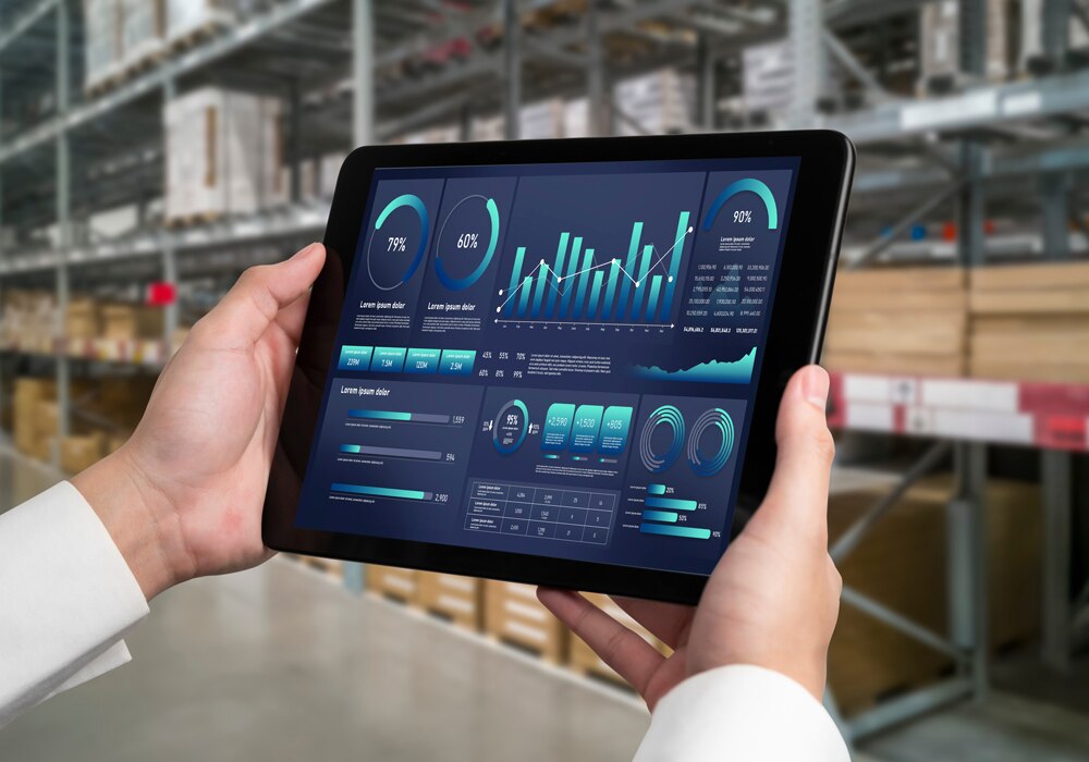 倉庫の中で、タブレットを使って在庫管理やデータ分析を行う作業員の手元のイメージ画像
